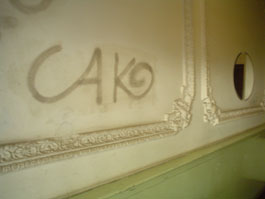 Vorher: Heruntergekommene Wand im Hausflur mit Graffiti